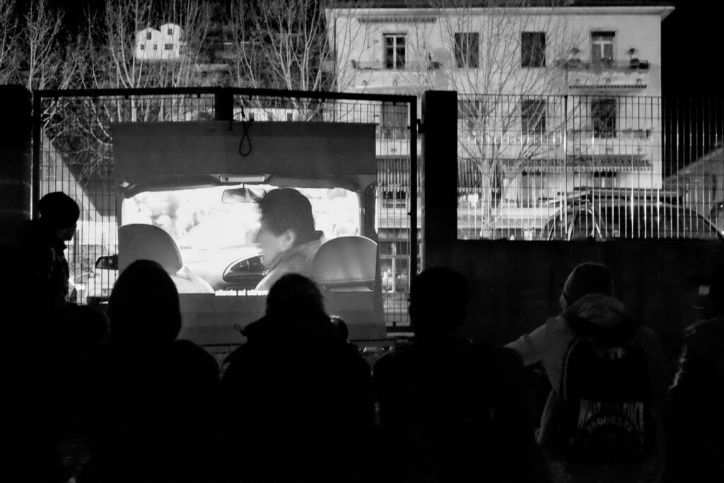 Maintaining a sense of normality becomes essential in precarious conditions; for this reason, some volunteers brave the night in the camp to organize film screening evenings.