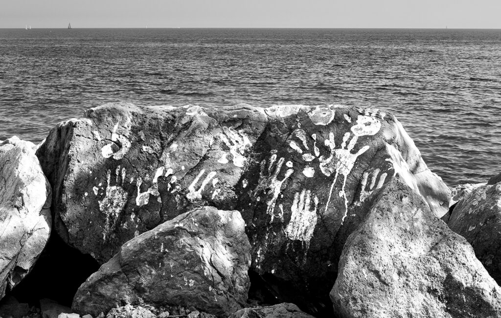 The handprints of activists and migrants remain marked on the cliffs of Balzi Rossi, near the Ponte San Ludovico border crossing, where in 2015 — following the closure of the border by French authorities — hundreds of people sought shelter.