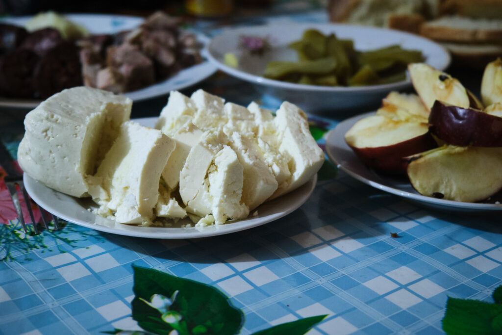 Vicislav, a Moldovan farmer who opened his house to shelter refugees, shares with us and the refugees he’s hosting some homemade food, including wine and cheese. Saiti, Moldova, March 19, 2022.