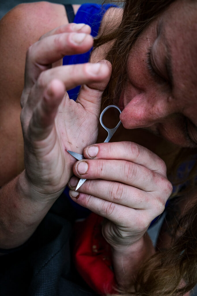 Valentina, a rigger, removes a metal splinter from her hand at the end of her shift after it pierced through her protective gloves. Ferrara, August 2023.