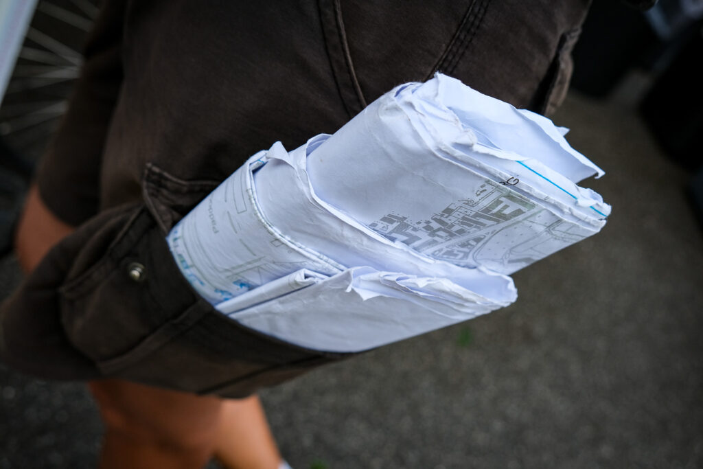 Detail of technical plans in the pocket of a site manager during the setup of a concert area. Site managers coordinate the different teams involved in the construction of the stage and oversee the logistics of the site. Ferrara, August 20th 2023.