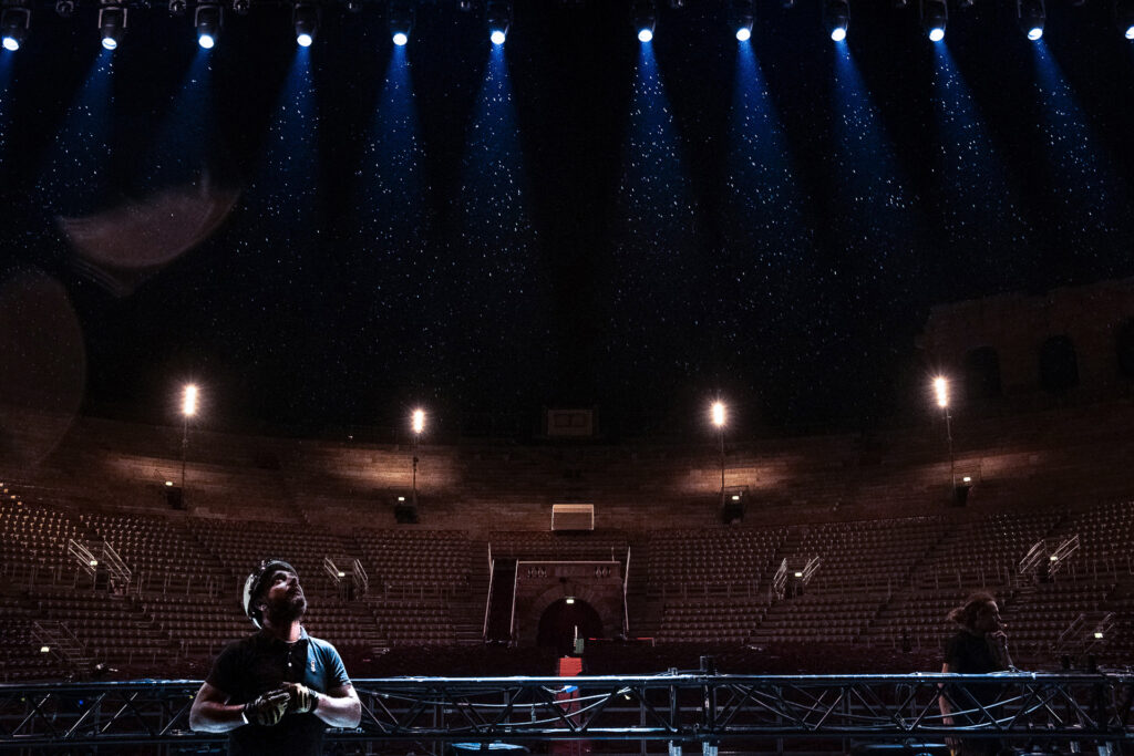 Mauro, a rigger and team leader, watches his crew dismantling the Space Roof structure as rain begins to fall over the Arena di Verona, July 2022.